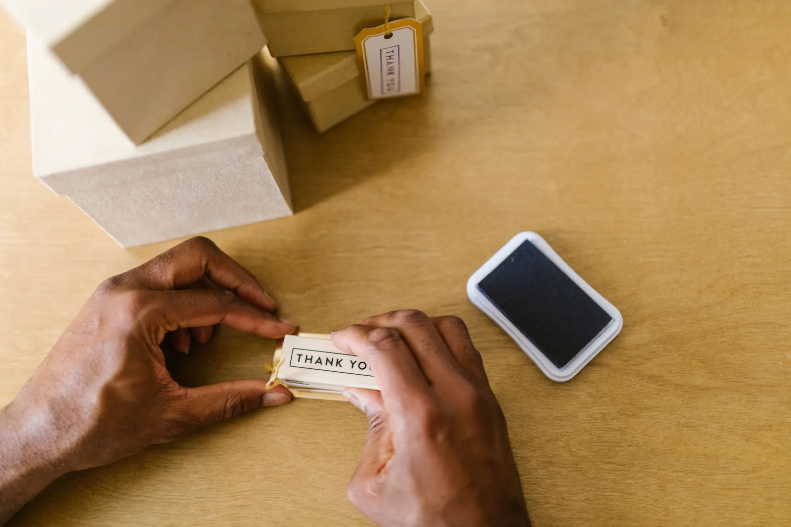 Hands of a small business owner sealing thank you cards with an ink pad. SBA loans: 7(a) guarantee and selected fee tiers
