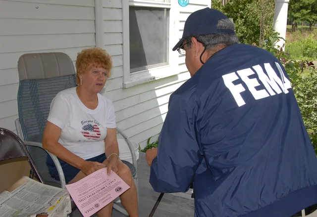Agency, MO, 6-23-07 -- FEMA Community Relations Specialist Luis Miranda talks with Dorothy Lavnick who received her FEMA housing check in 5 days, but now needs to fill out her SBA loan application to be considered for other FEMA aid. Community Relation Specialists are out in the flood damaged area t. SBA loans requirements: programs, forms and eligibility
